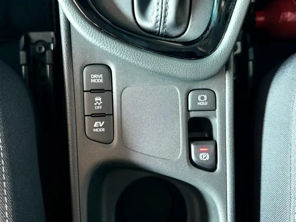 Gros plan sur la console centrale de la Toyota Yaris Hybrid 2025, montrant les boutons Drive Mode, EV Mode et frein de parking électrique.