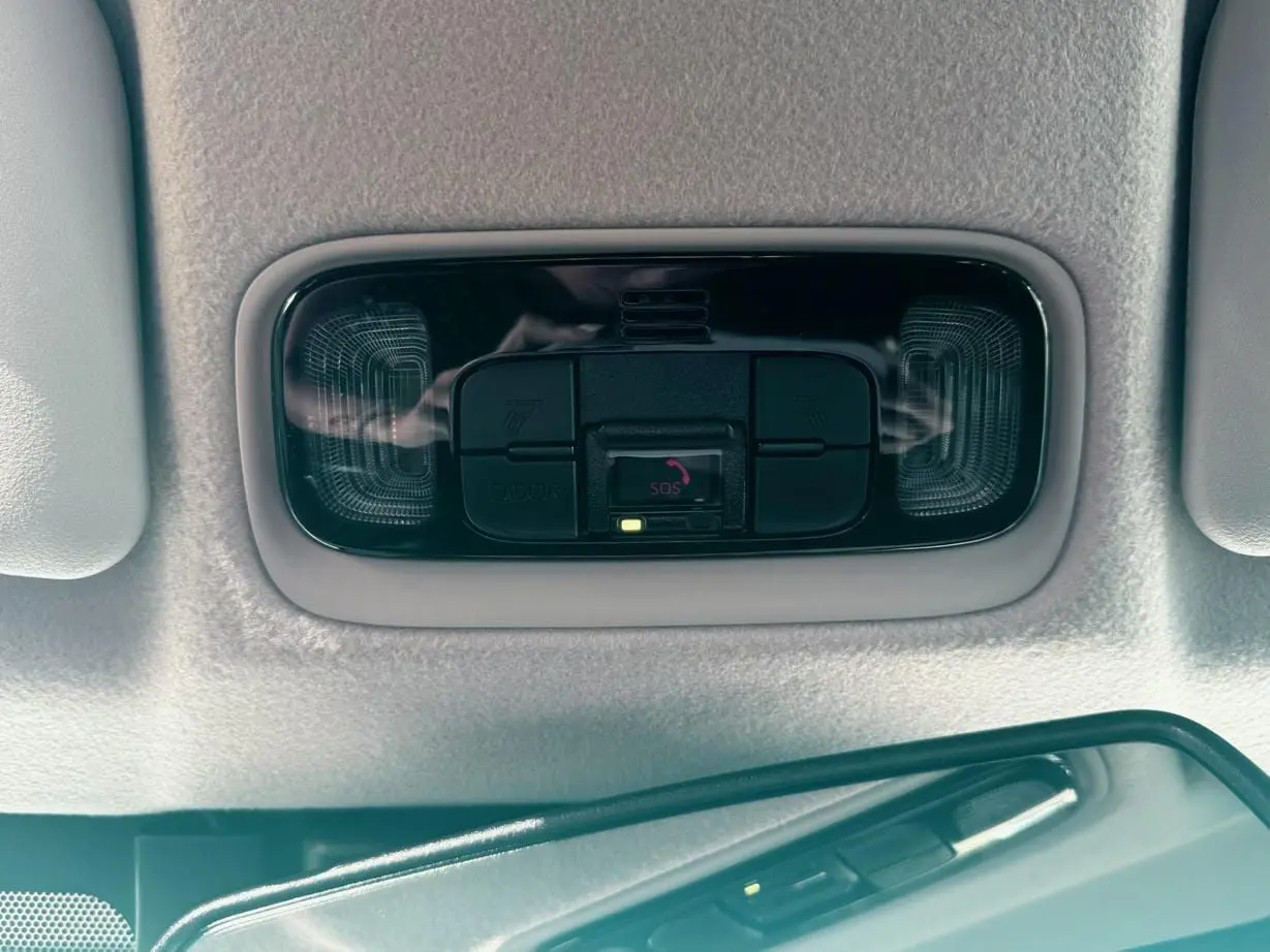 Plafonnier intérieur avec commandes SOS et éclairage, vue en gros plan dans une Toyota Yaris Hybrid 2025 noire.
