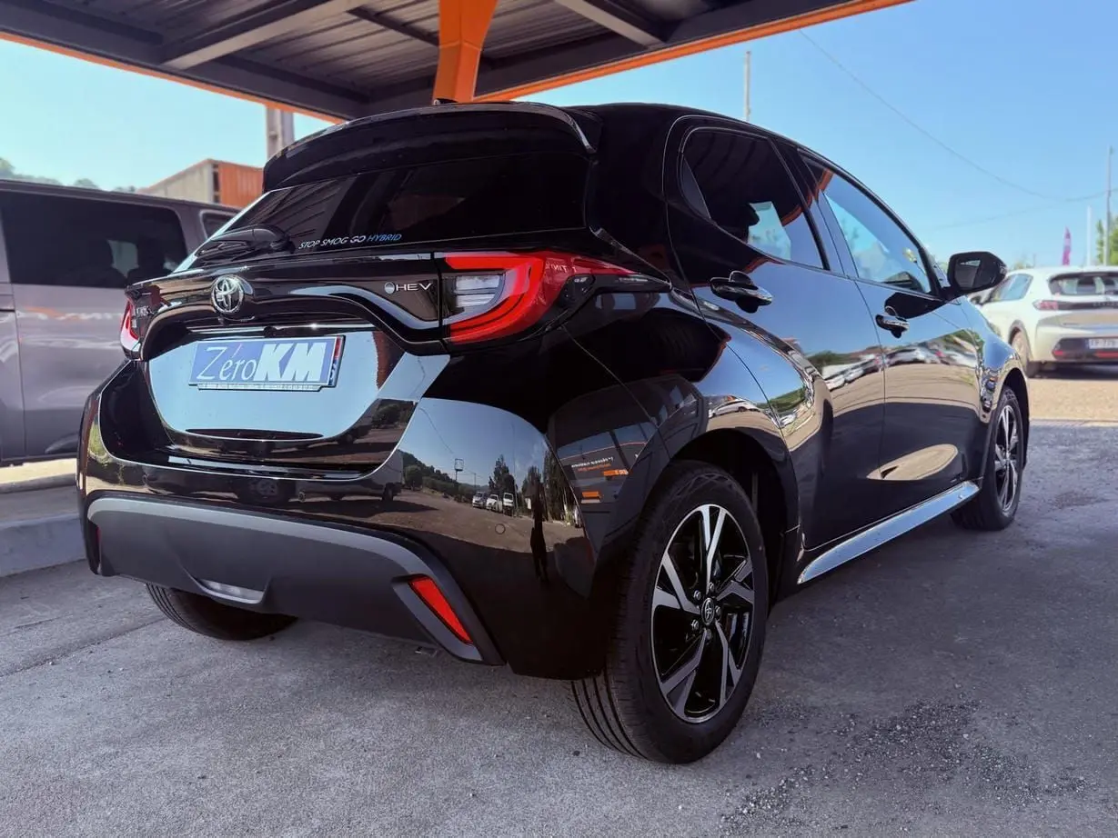 Toyota Yaris Hybrid noire vue en 3/4 arrière droit, avec feux arrière LED et jantes alliage noires.