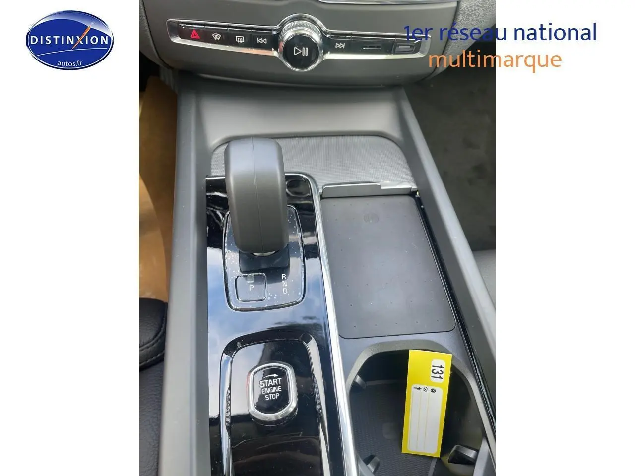 Gros plan sur la console centrale du Volvo XC60 gris 2024, avec levier de vitesse automatique et bouton start/stop.