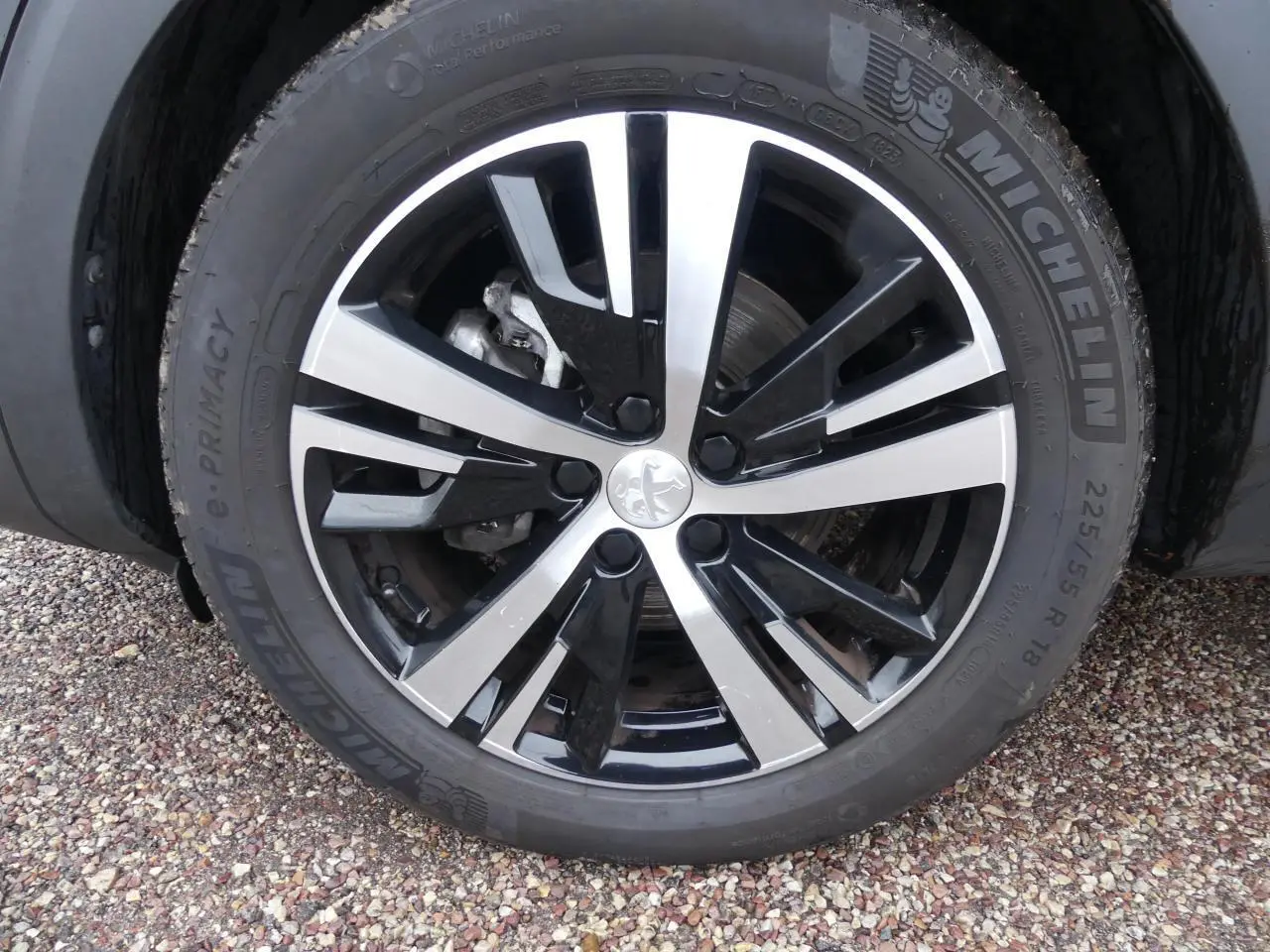 Gros plan sur la jante alliage 18 pouces bi-ton noir et argent du Peugeot 5008 GT noir métallisé.