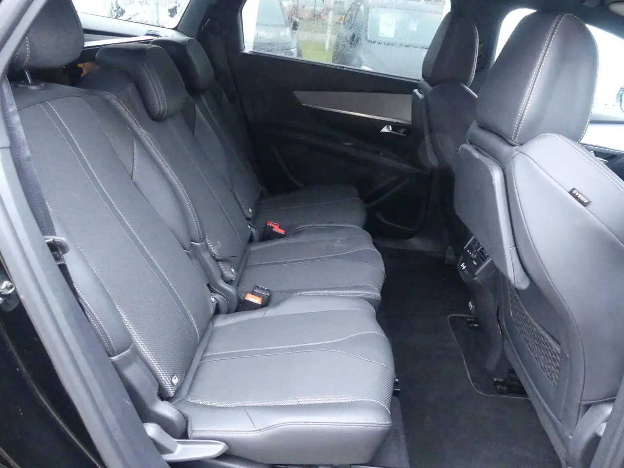Vue intérieure côté gauche sur les sièges arrière noirs en cuir du Peugeot 5008 GT 2023 avec finitions soignées.