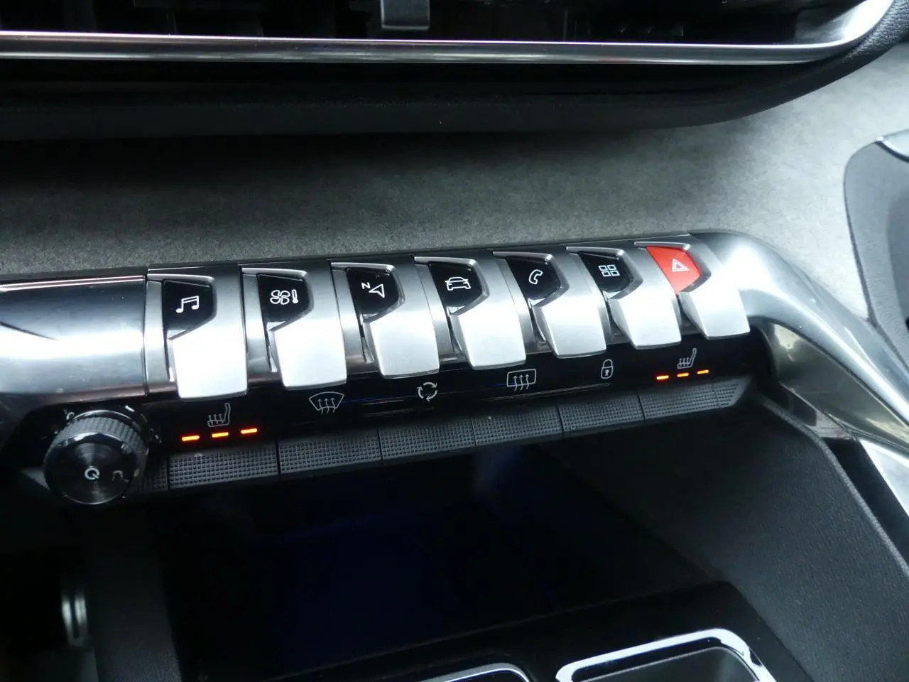 Gros plan sur la rangée de commandes chromées et boutons tactiles du tableau de bord du Peugeot 5008 GT noir métallisé.