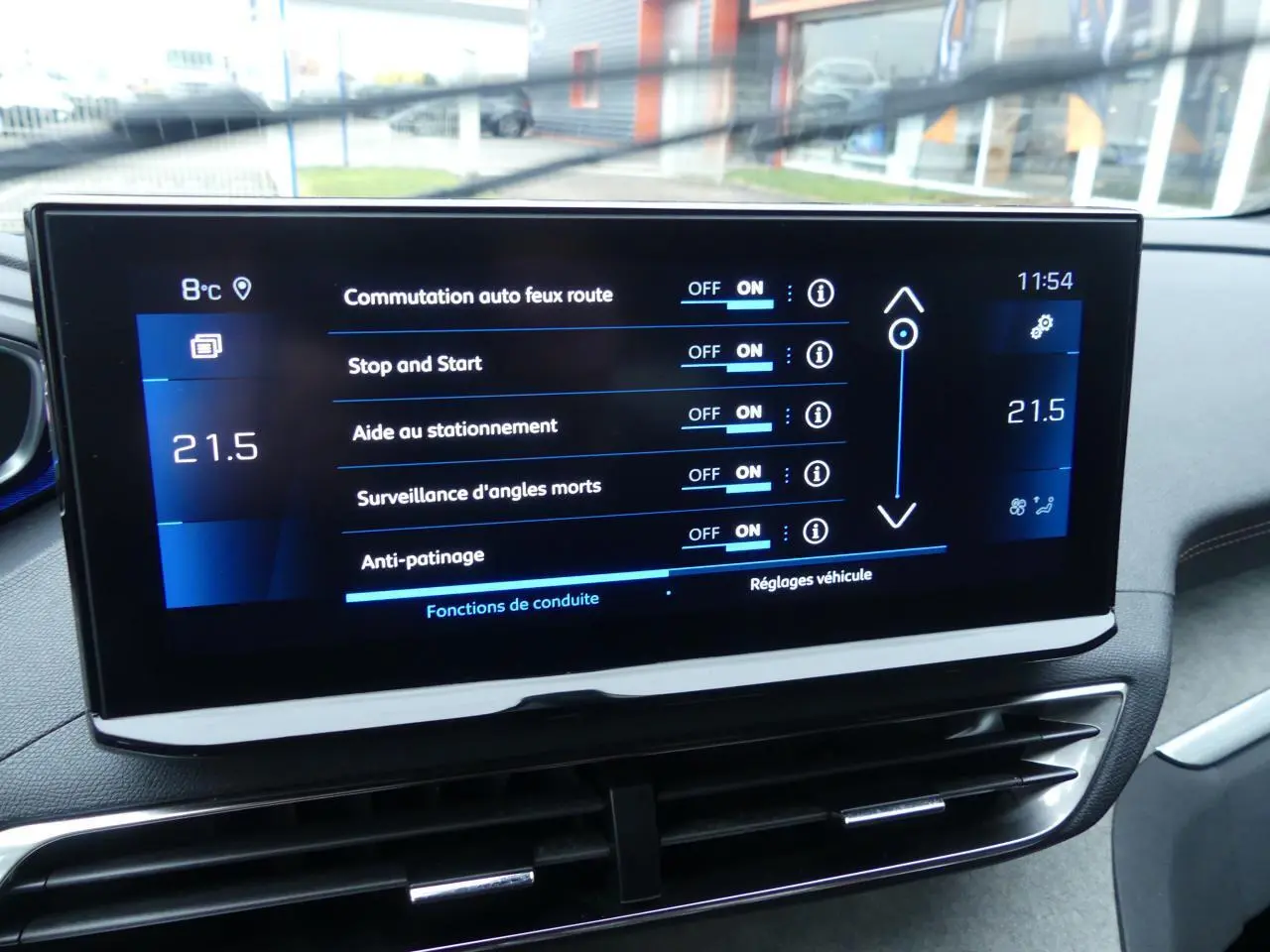 Écran tactile central du Peugeot 5008 GT 2023 affichant les réglages d'aides à la conduite et la température intérieure