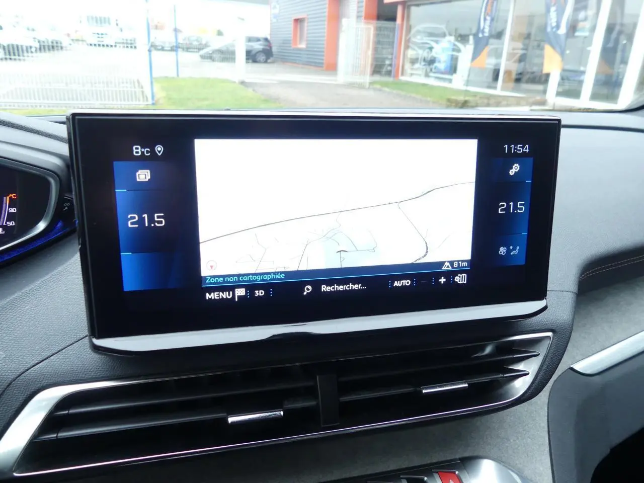 Écran tactile central du tableau de bord du Peugeot 5008 GT 2023, avec navigation et climatisation à 21,5°C.