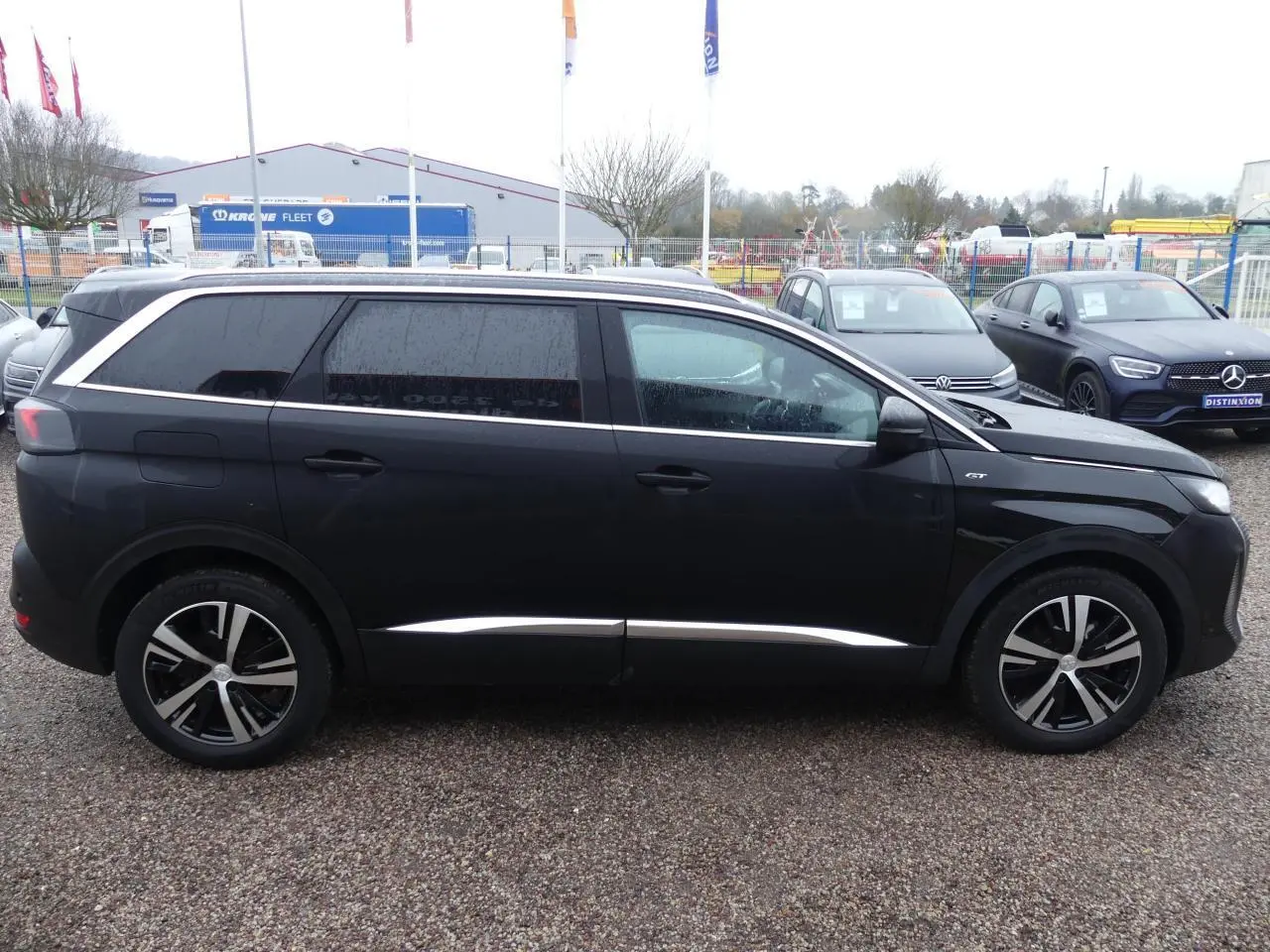 Profil côté gauche d'un Peugeot 5008 GT noir métallisé avec jantes alliage bicolores et vitres arrière surteintées.