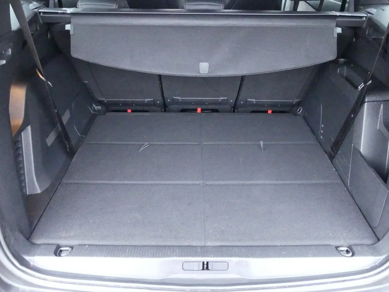 Coffre ouvert du Peugeot 5008 GT 2023 noir métallisé, montrant l'espace de chargement avec banquette arrière rabattue.