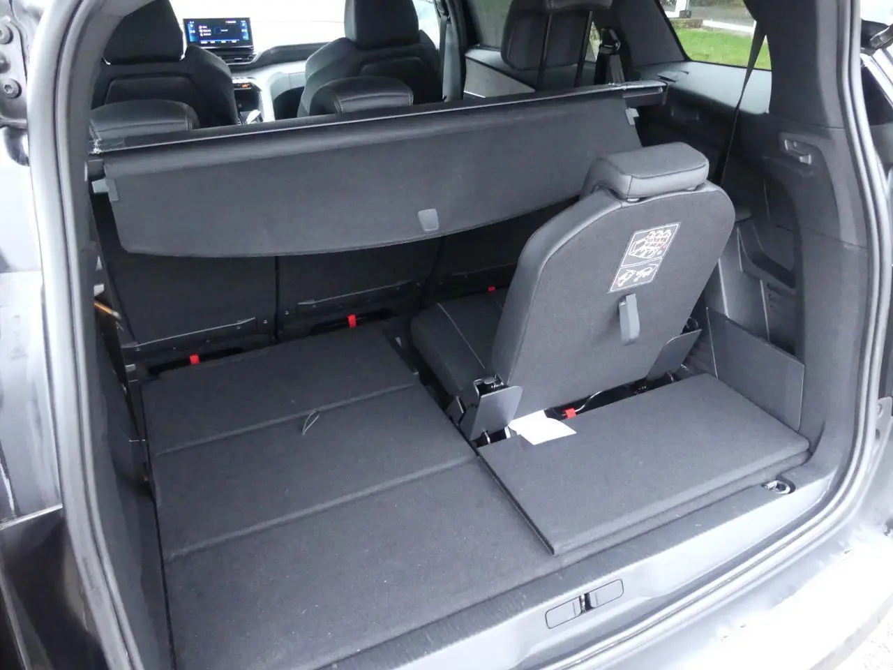 Coffre ouvert du Peugeot 5008 GT noir métallisé montrant siège arrière escamoté et plancher plat du coffre.