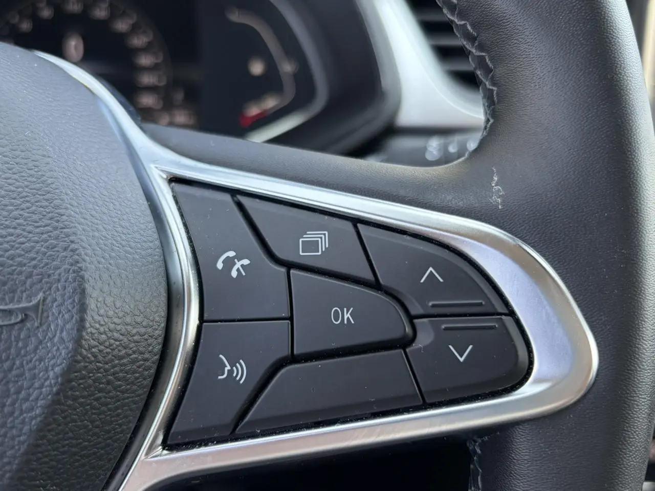 Gros plan sur les commandes multifonctions noires du volant du Renault Captur 2024, finition Techno.