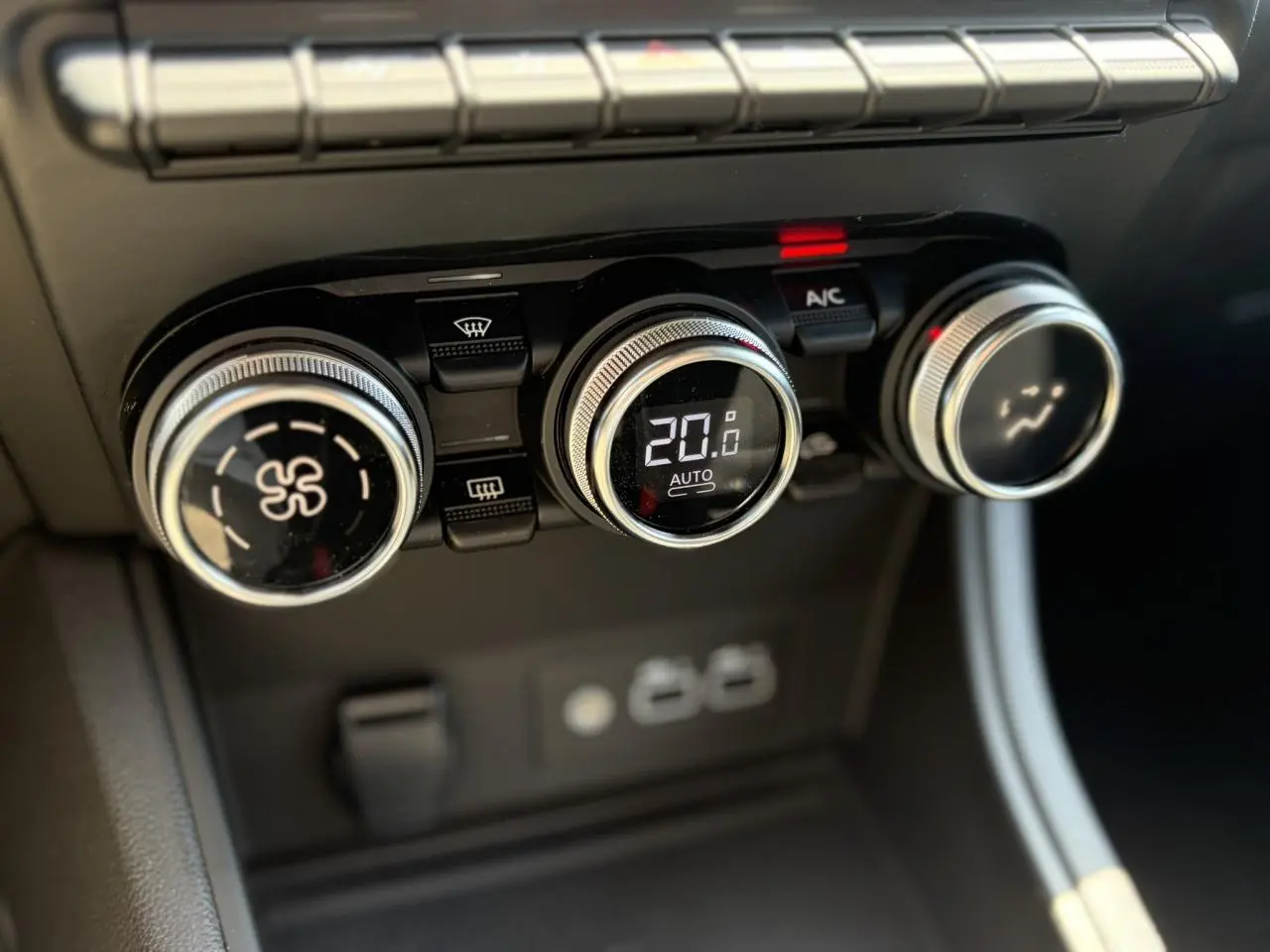 Gros plan sur les commandes de climatisation digitale du Renault Captur 2024, affichant 20°C en mode automatique.