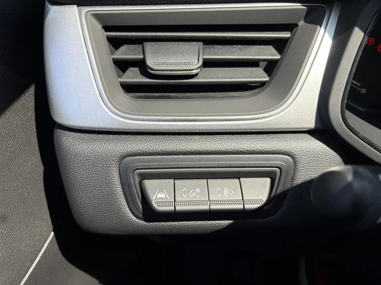 Détail des commandes d'assistance à la conduite sur le tableau de bord noir du Renault Captur TCE 90 Techno.