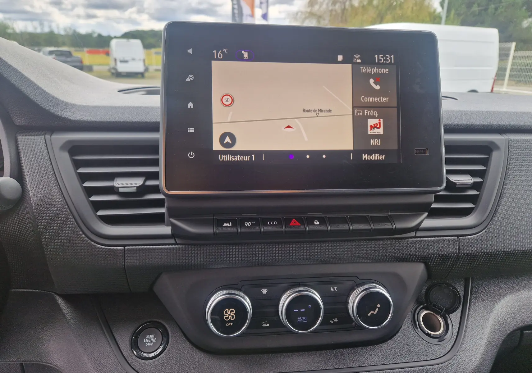 Tableau de bord du Renault Trafic Fourgon gris urbain 2025 avec écran tactile central affichant la navigation.