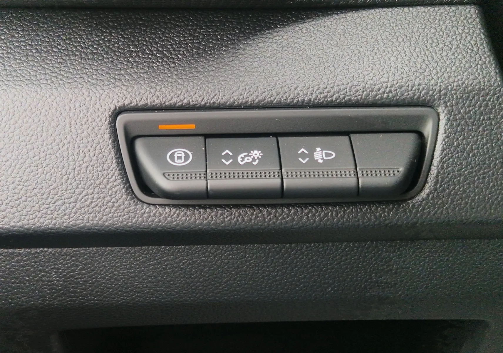 Boutons de réglage de verrouillage, luminosité et hauteur des phares sur le tableau de bord du Renault Trafic Fourgon gris urbain.