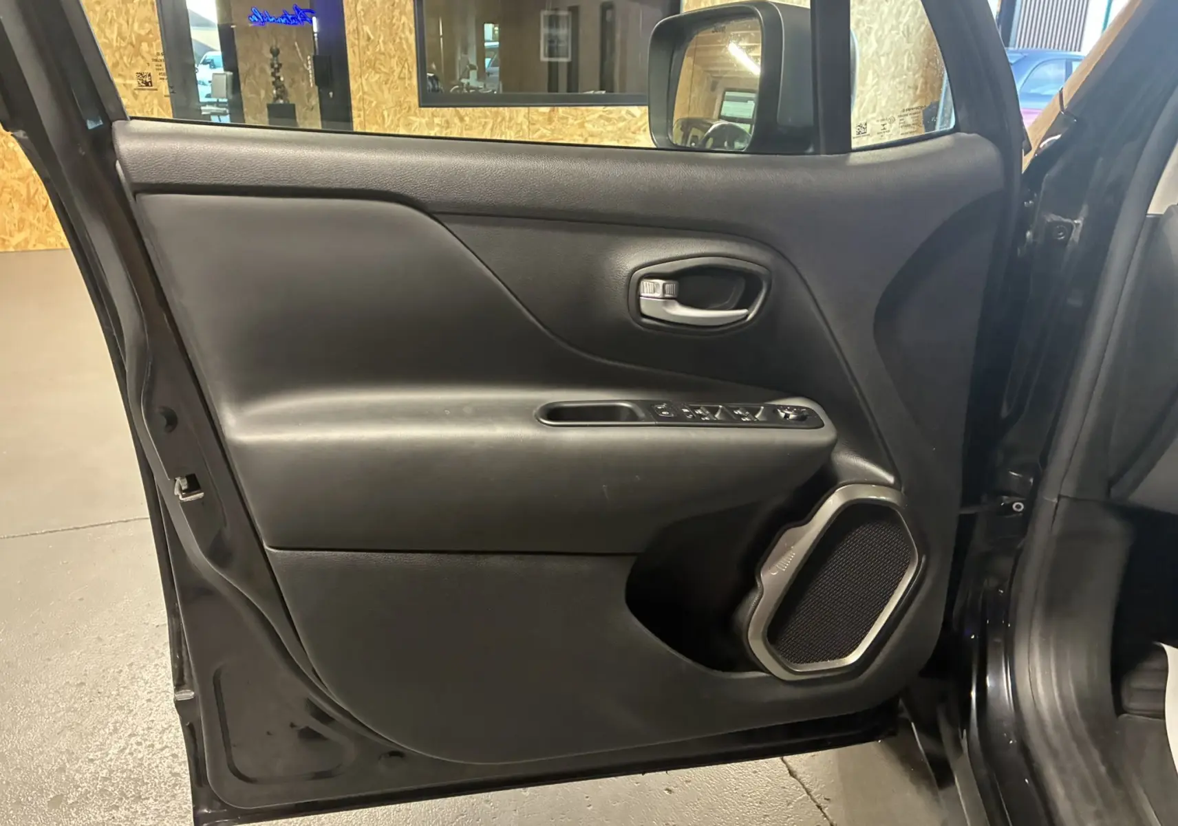 Vue intérieure de la porte arrière droite noire du Jeep Renegade 2019, avec commandes électriques et haut-parleur intégré.