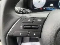 Gros plan sur les commandes au volant d'une Hyundai i20 2025 noire Phantom Metal, mettant en valeur les boutons multifonctions.