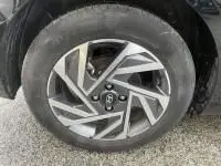 Gros plan sur la jante en alliage argentée et noire d'une Hyundai i20 2025 noir Phantom Metal, avec pneu visible.