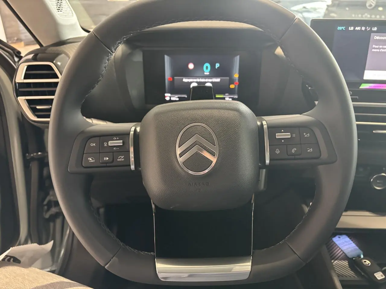 Volant cuir multifonctions Citroën C4 2026 vu de face, avec tableau de bord numérique et commandes intégrées.