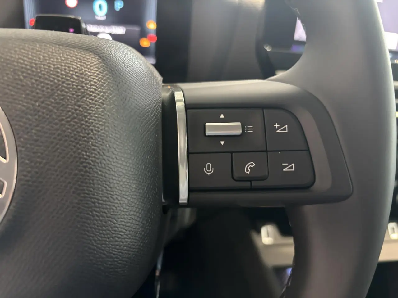 Gros plan sur les commandes vocales et téléphoniques au volant cuir de la Citroën C4 hybride 2026.