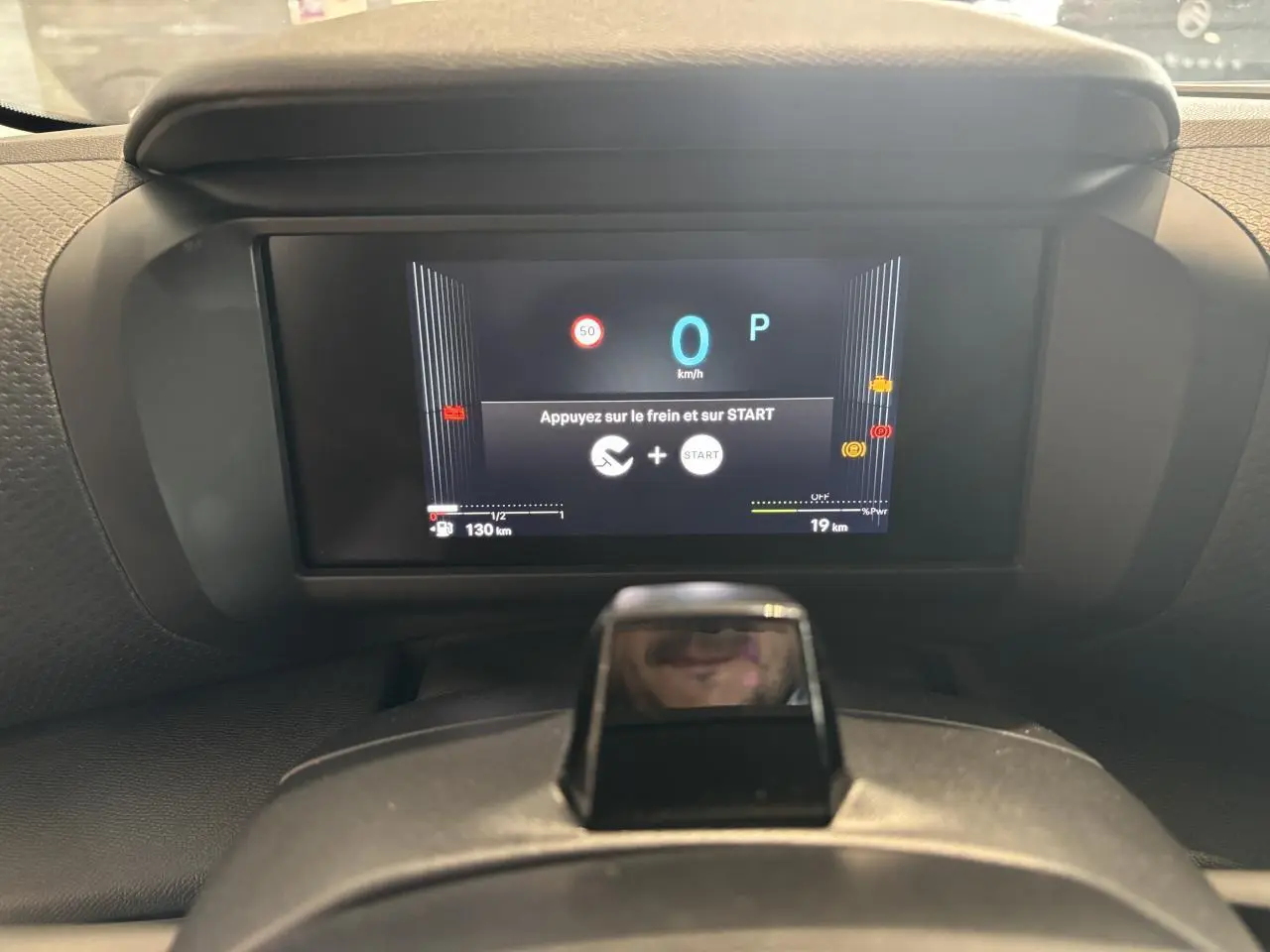 Vue rapprochée du tableau de bord numérique de la Citroën C4 hybride affichant un message de démarrage.