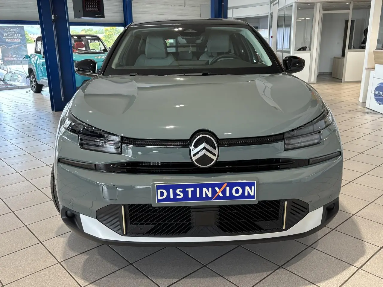 Vue frontale d'une Citroën C4 1.2i Hybride 2026 en vert Manhattan avec toit noir et détails noirs brillants.