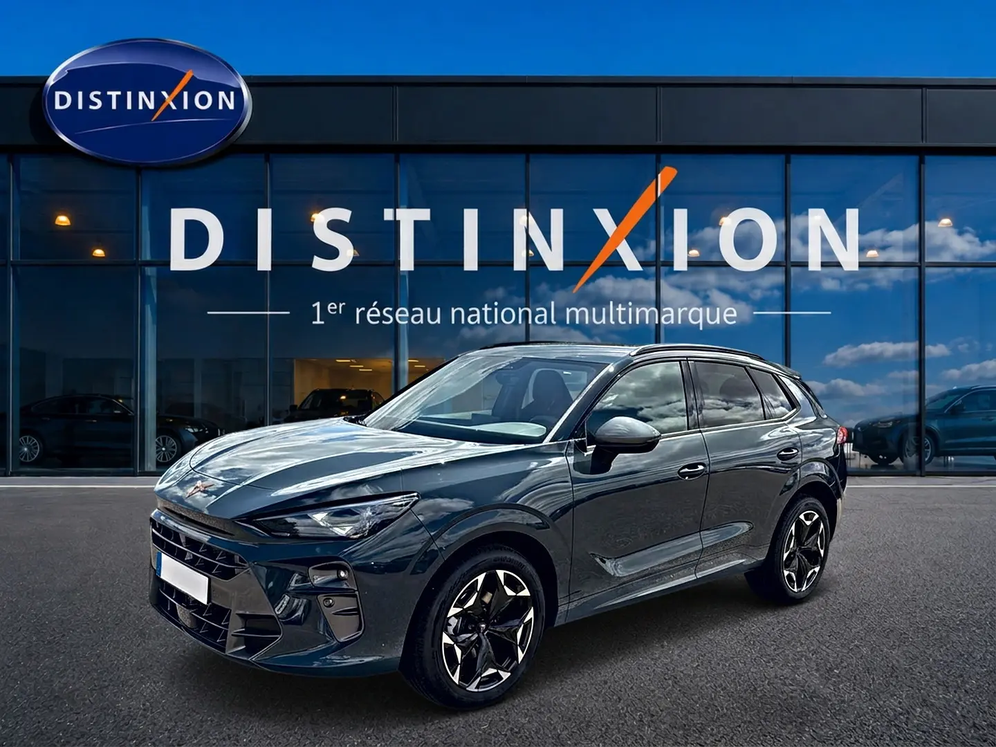 Vue 3/4 avant droite d'une CUPRA Terramar 2026 bleu fjord avec jantes 19 pouces devant une vitrine Distinxion.