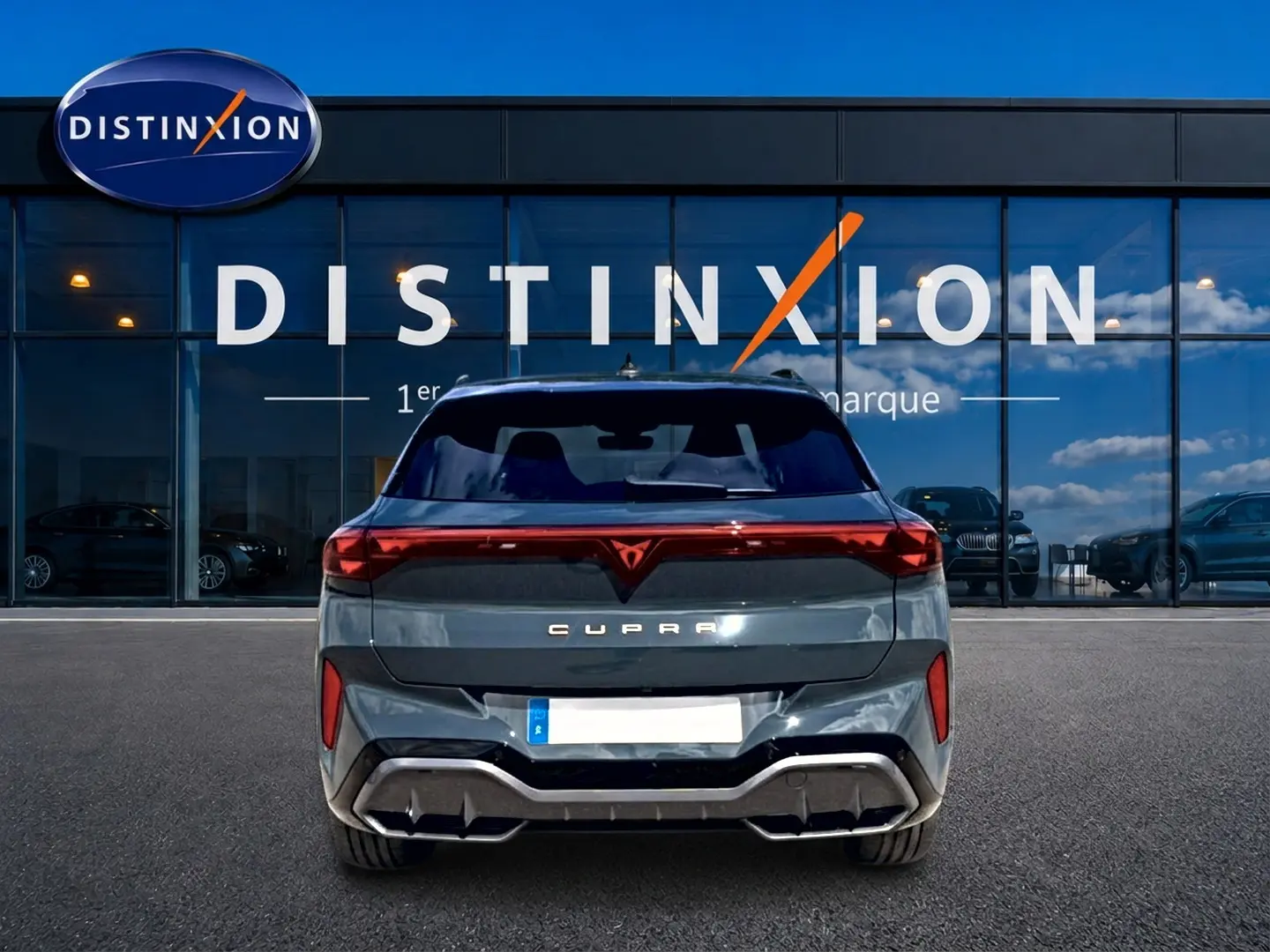 Vue arrière d'une CUPRA Terramar bleu fjord garée devant une vitrine avec logo Distinxion.