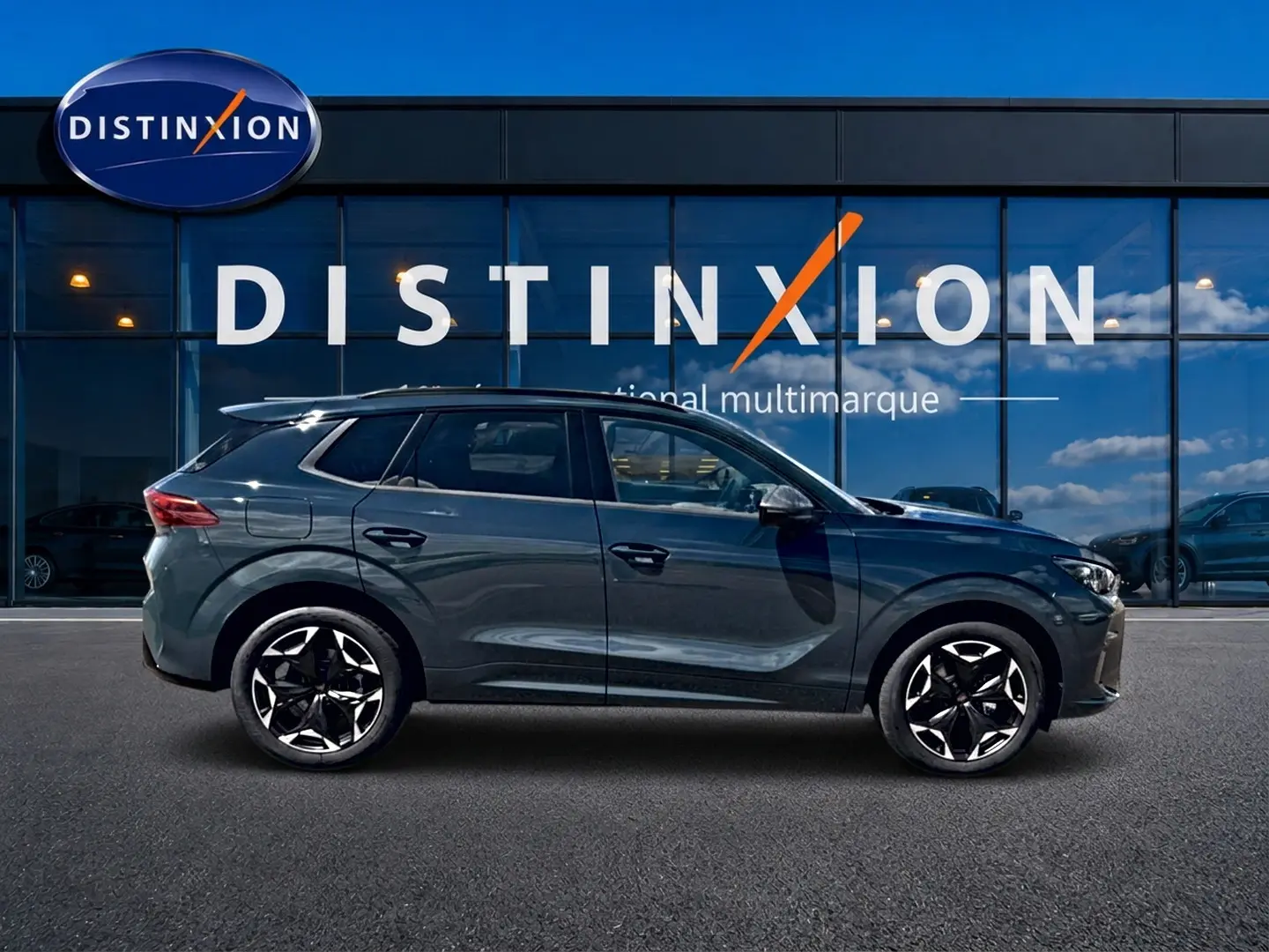 Vue latérale droite d'un CUPRA TERRAMAR 2026 bleu fjord avec jantes 19 pouces devant une vitrine Distinxion.