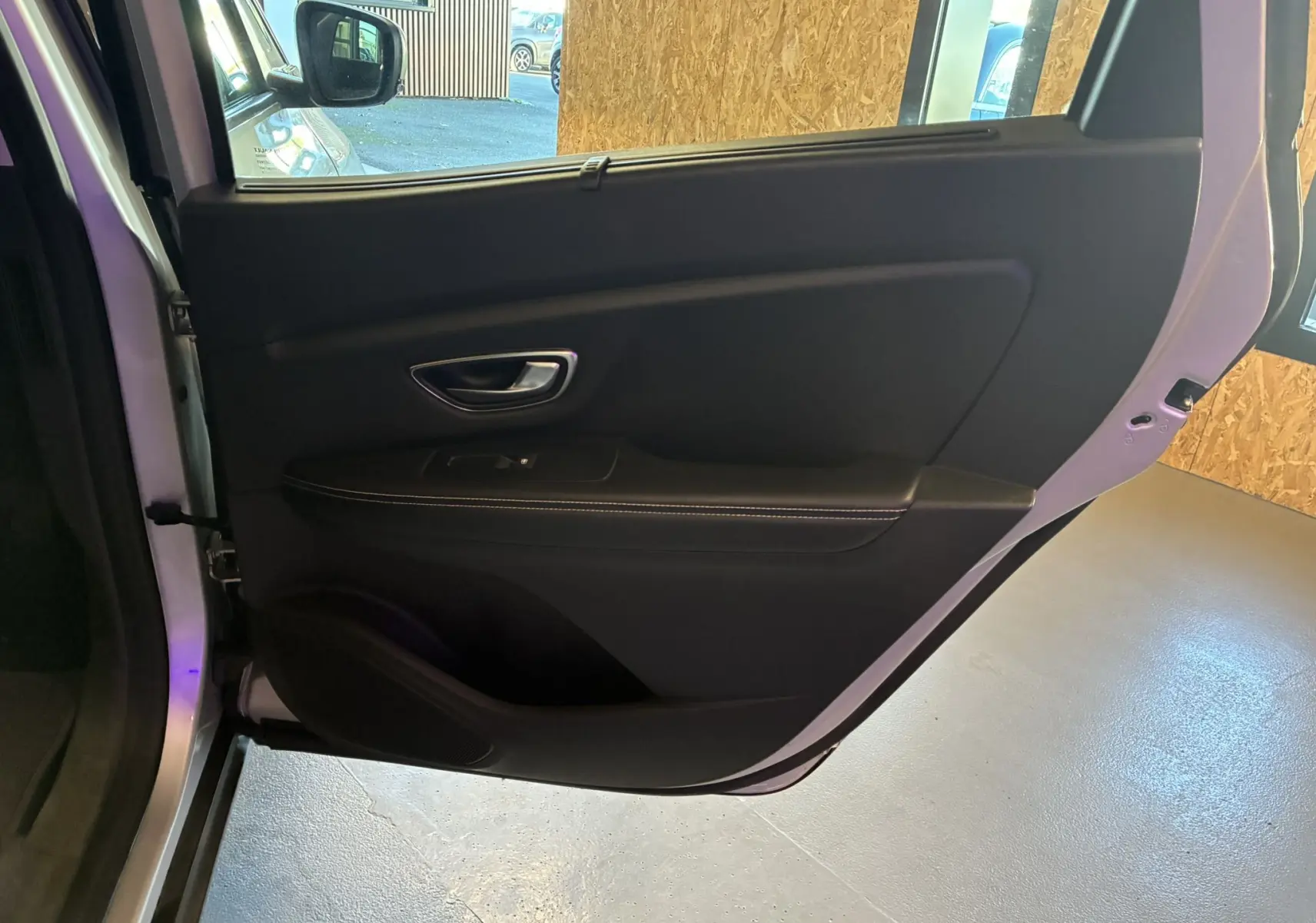 Porte arrière droite ouverte du Renault Grand Scenic gris 2017, intérieur noir avec poignée et commande de vitre visible.