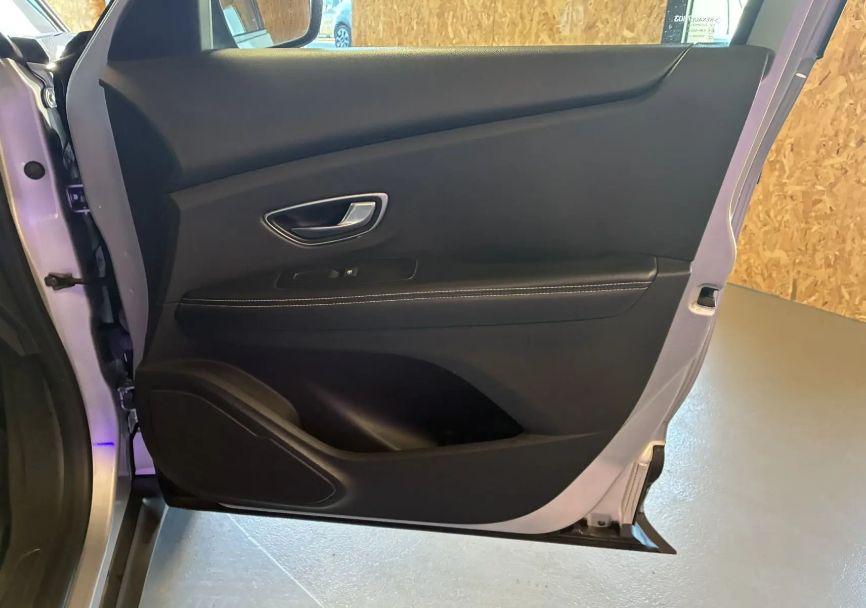 Vue intérieure de la porte arrière gauche gris foncé du Renault Grand Scenic 2017 avec poignée argentée et garniture noire.