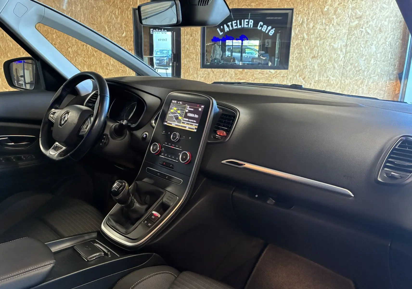 Intérieur noir du Renault Grand Scenic 1.5 dCi 110 Business, vue de profil côté conducteur avec console centrale tactile et boîte manuelle.