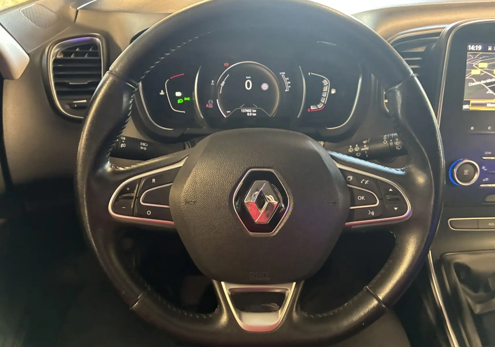 Vue rapprochée du volant noir en cuir du Renault Grand Scenic 1.5 dCi 110 Business avec tableau de bord et écran GPS visibles.