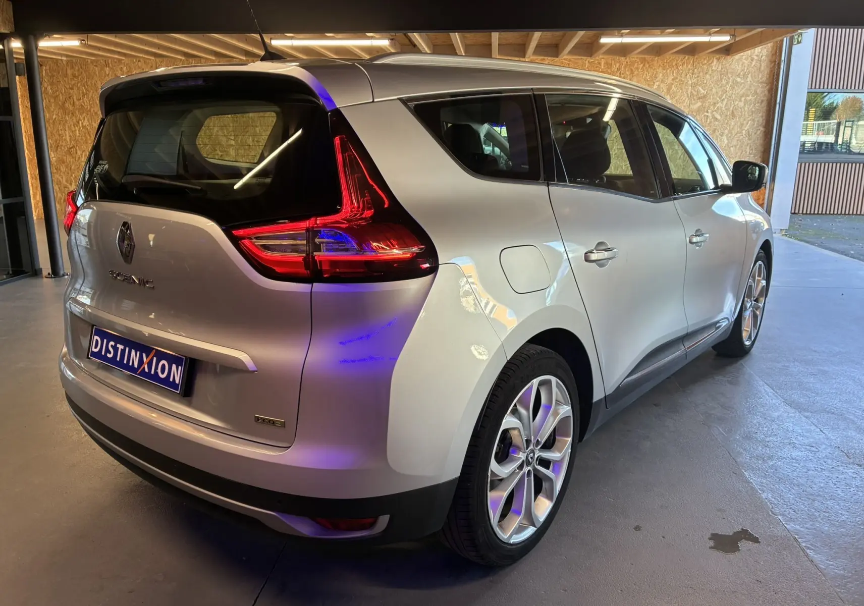 Vue 3/4 arrière droite d'un Renault Grand Scenic gris 2017 avec feux arrière LED et jantes alliage biton.