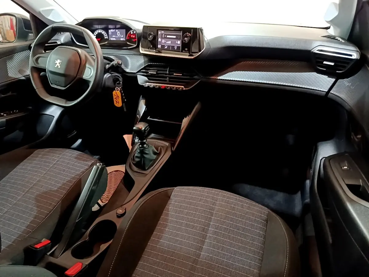 Intérieur de la Peugeot 208 1.5 BlueHDi 2022 vu côté conducteur, tableau de bord avec écran tactile et volant compact noir.