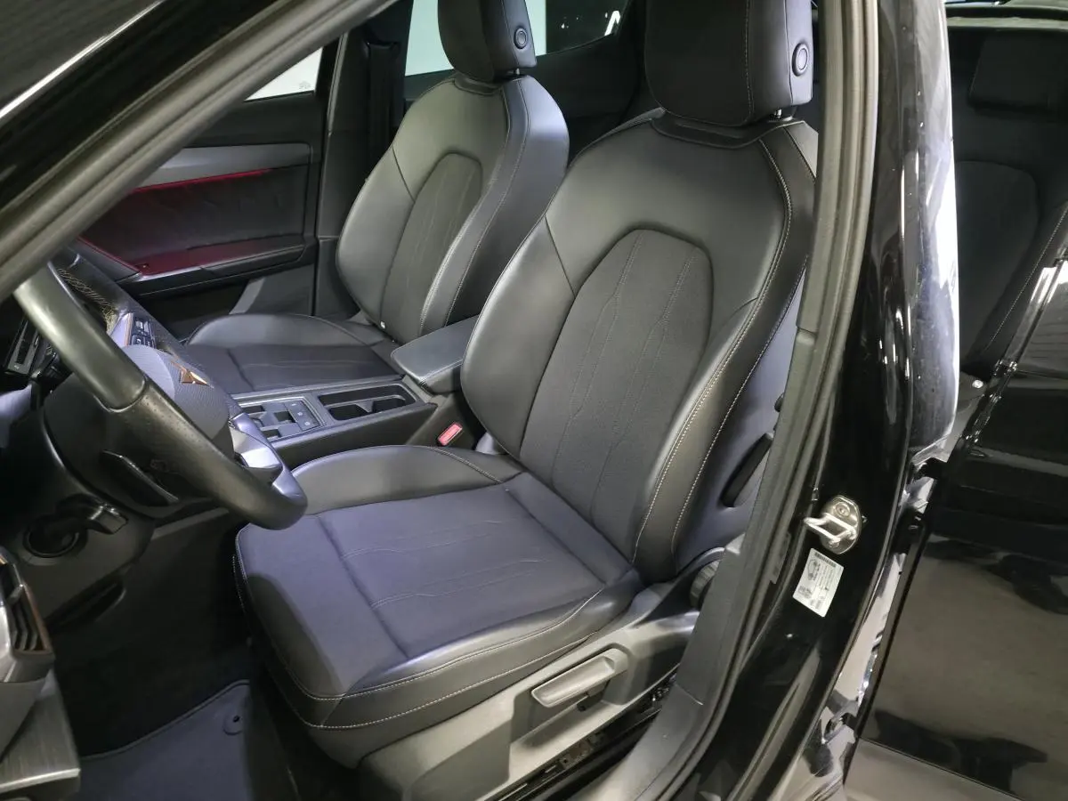 Vue intérieure côté conducteur du CUPRA Formentor noir, mettant en valeur les sièges sport en textile et cuir avec surpiqûres contrastantes.