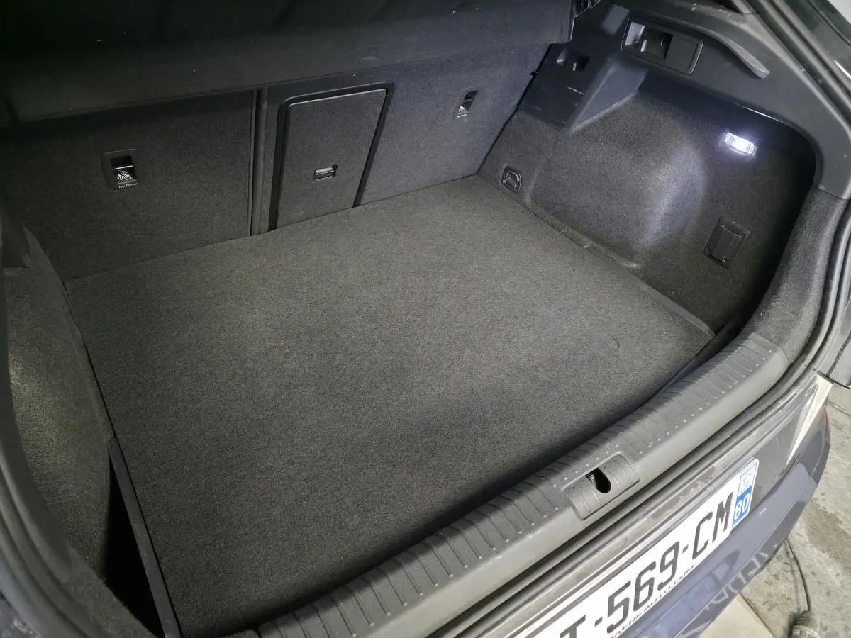 Coffre ouvert vu de l'arrière d'une CUPRA Formentor noir, montrant un espace de chargement propre et éclairé.
