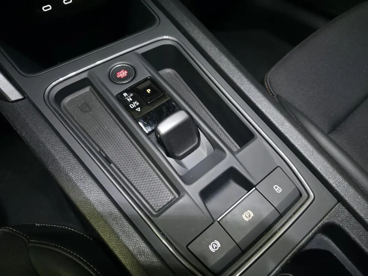 Gros plan sur la console centrale noire du CUPRA Formentor 1.4 e-Hybrid avec levier de vitesse et bouton Start/Stop rouge.