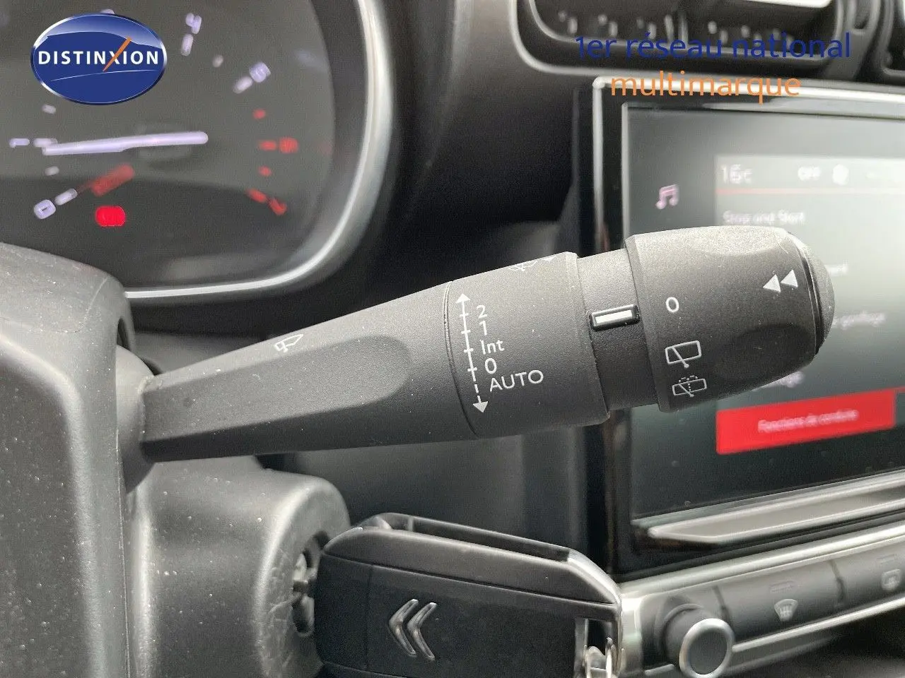 Gros plan sur la commande des essuie-glaces à gauche du volant dans l'habitacle d'une Citroën C3 Aircross 2023.