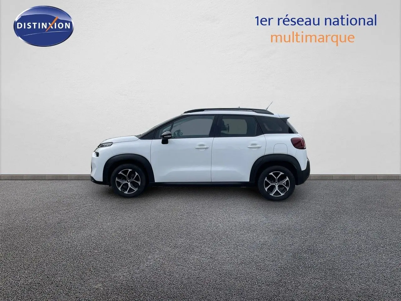 Profil côté gauche d'un Citroën C3 Aircross blanc polaire avec toit noir et jantes alliage bicolores.