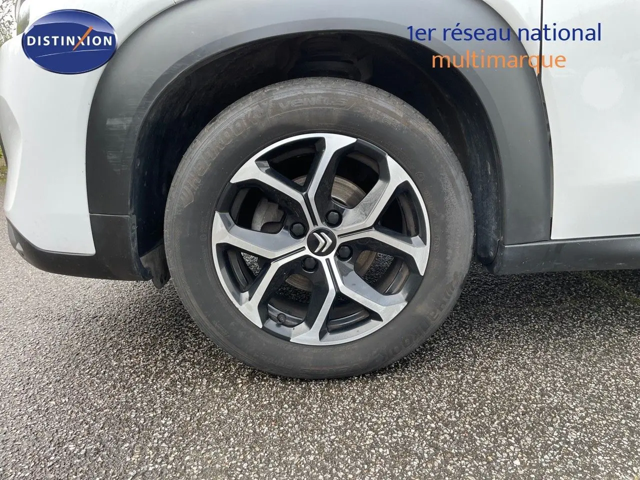 Gros plan sur la roue avant gauche d'une Citroën C3 Aircross blanc polaire avec jante alliage distinctive.