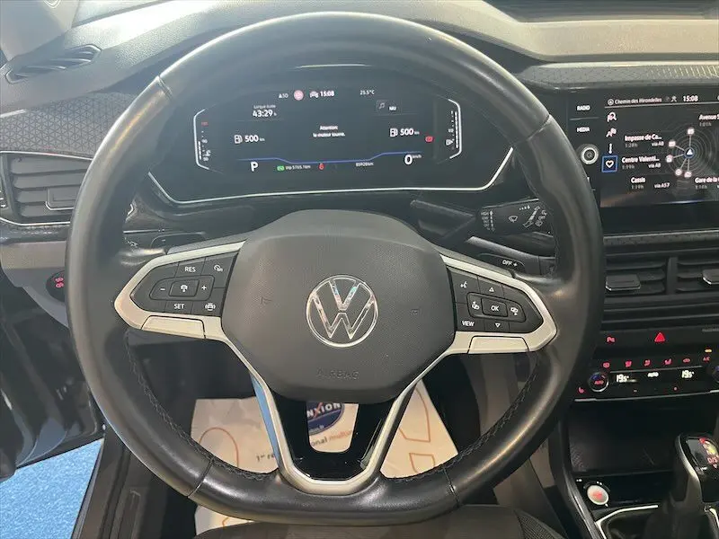 Vue rapprochée du volant multifonction noir du Volkswagen T-Cross 2021 avec tableau de bord numérique et écran central tactile.