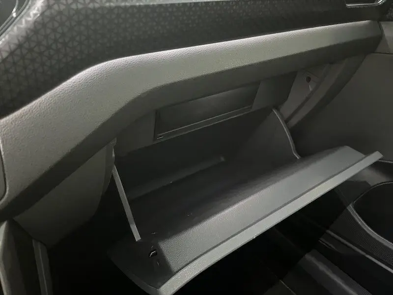 Vide-boîte à gants ouvert côté passager dans l'habitacle gris foncé du Volkswagen T-Cross 2021.
