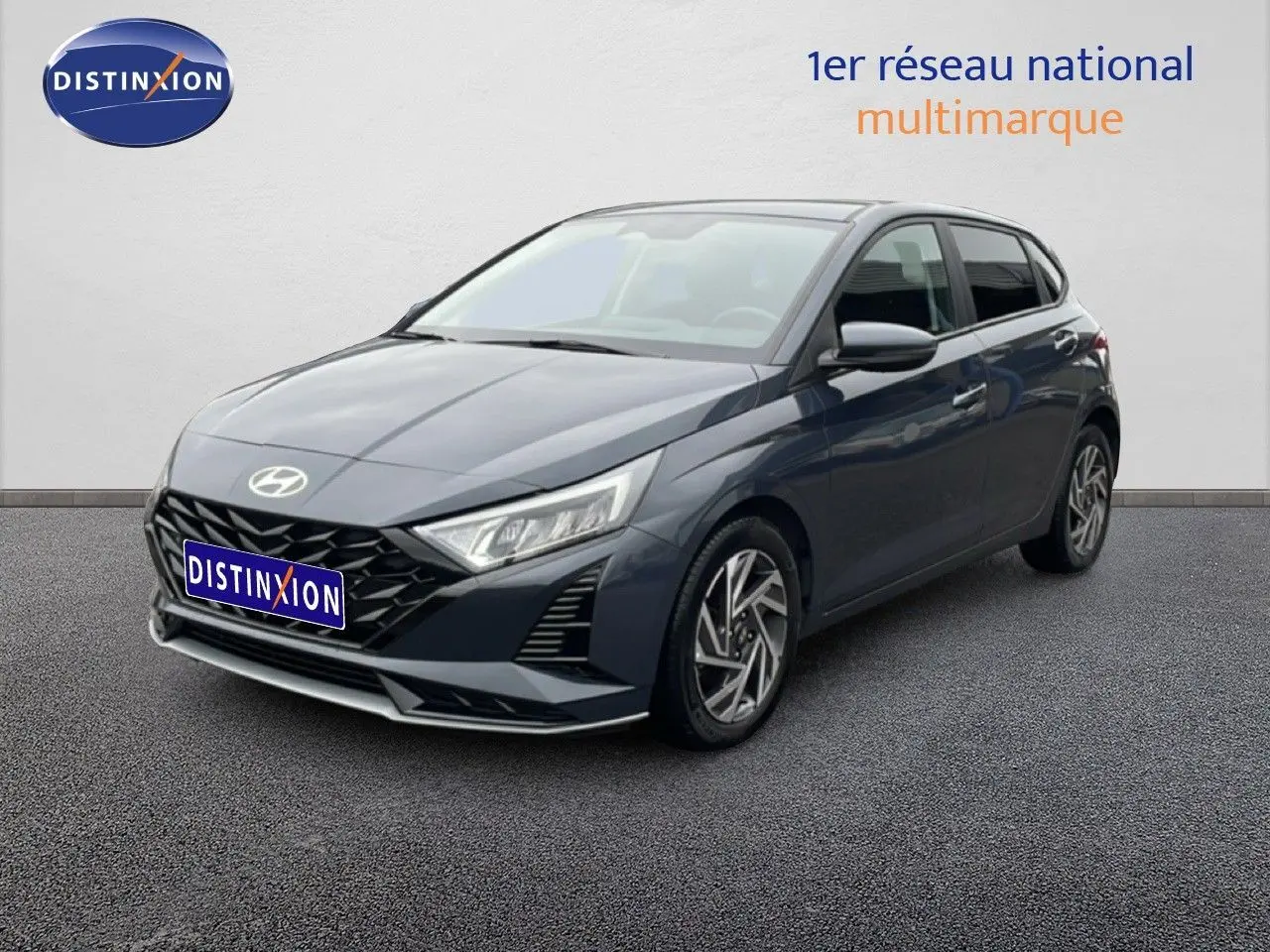 Hyundai i20 2025 gris Aurora Metal vue 3/4 avant droit avec calandre noire et jantes alliage distinctives.