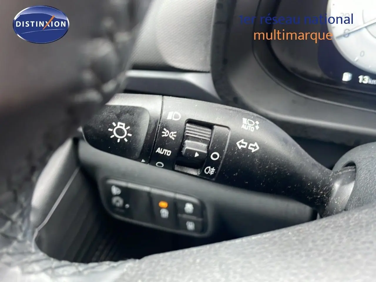 Gros plan sur la commande des feux et clignotants côté gauche du volant d’une Hyundai i20 gris Aurora Metal 2025.