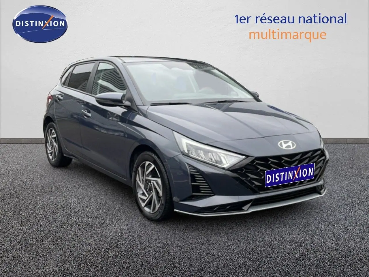 Vue 3/4 avant droit d'une Hyundai i20 2025 gris Aurora Metal avec calandre noire et jantes alliage.