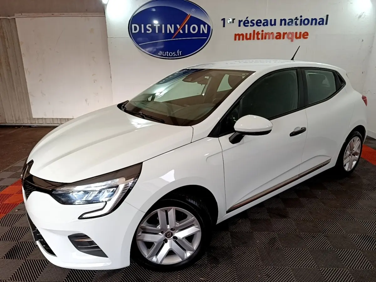 Renault Clio Business blanc vue 3/4 avant droit, feux LED allumés, jantes alliage et rétroviseur blanc.