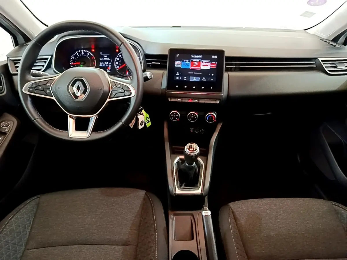 Vue intérieure avant de la Renault Clio Business blanche 2021, volant cuir, écran tactile central et boîte manuelle visible.