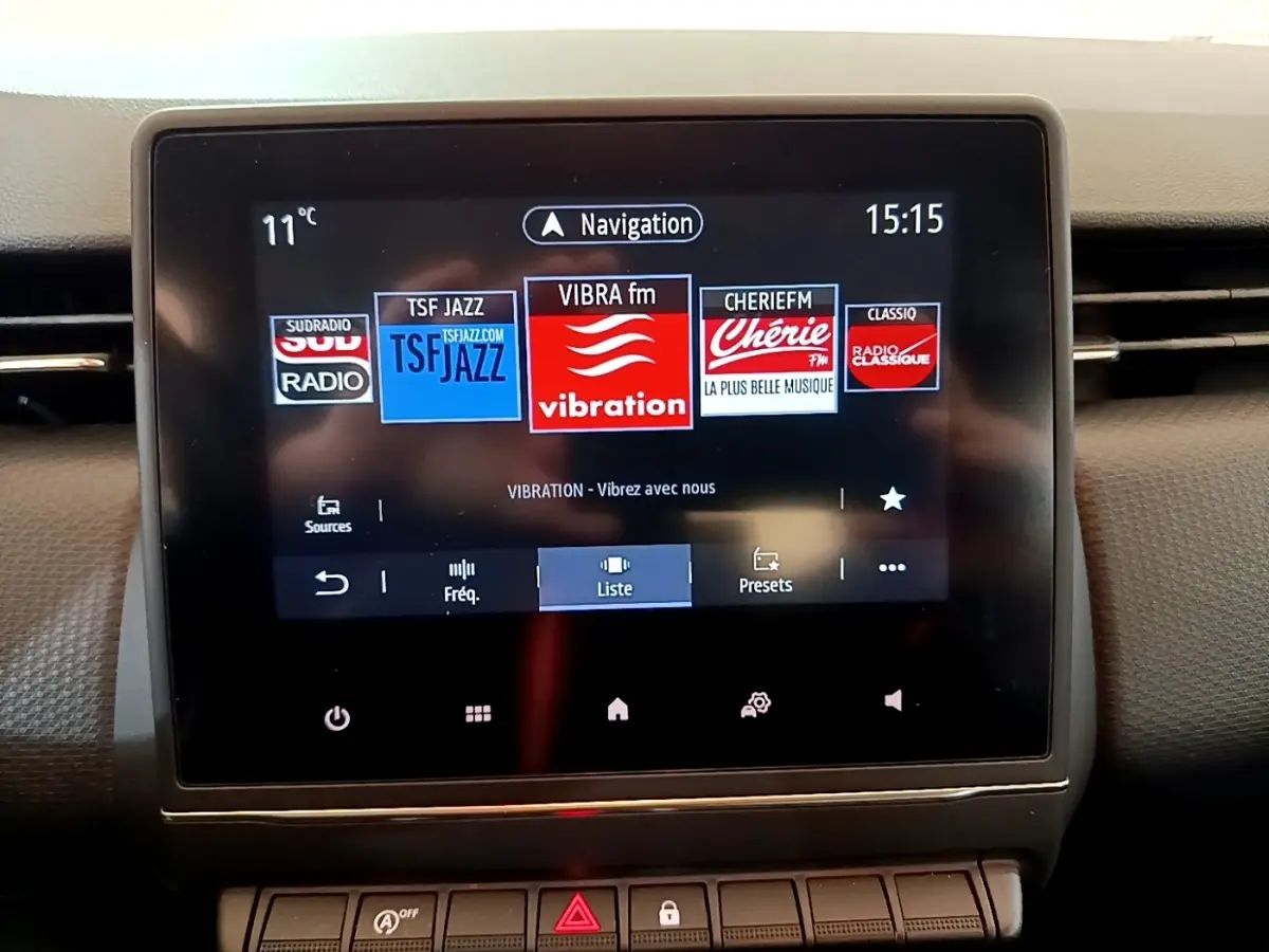 Écran tactile central de la Renault Clio Business blanc, affichant les stations radio avec interface moderne.