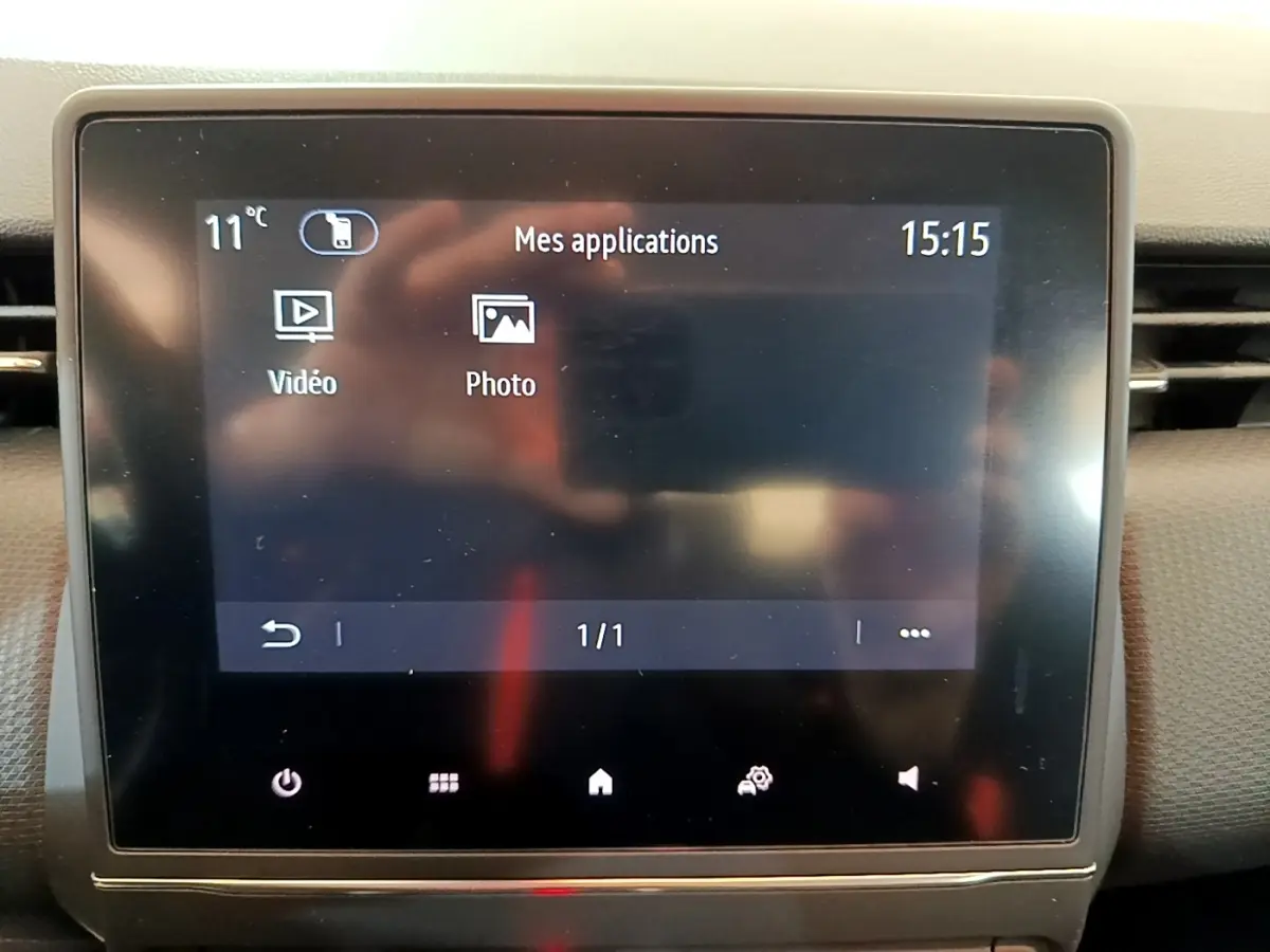 Écran tactile central de la Renault Clio Business blanc, affichant les applications vidéo et photo à 15h15.