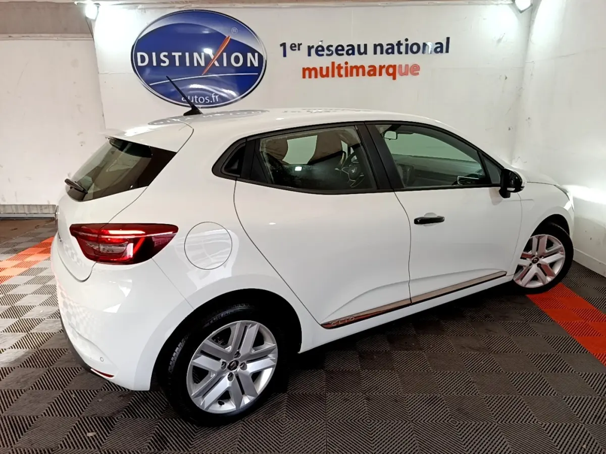 Renault Clio Business blanc vue de profil côté droit, avec jantes alliage et feux arrière allumés.