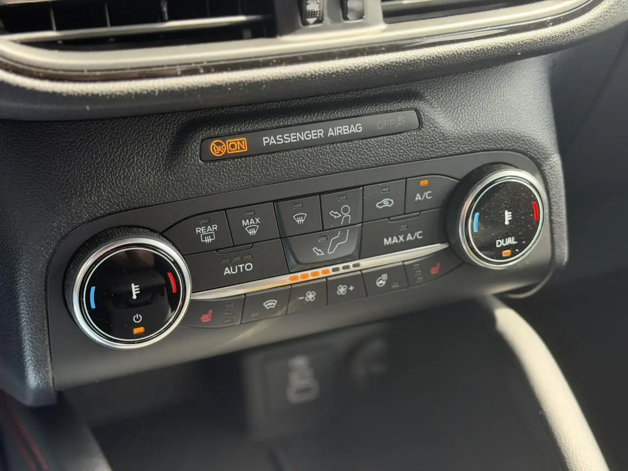 Gros plan sur la console de climatisation double zone du Ford Kuga 2024 avec commandes chauffantes et affichage lumineux.